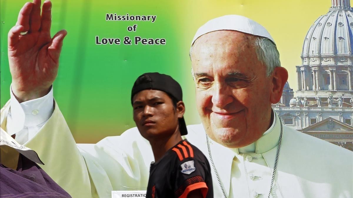 Un birmano camina junto a un poster que da la bienvenida a la visita apostólica del Papa, en Rangún, el 26 de noviembre. Un birmano camina junto a un poster que da la bienvenida a la visita apostólica del Papa, en Rangún, el 26 de noviembre.