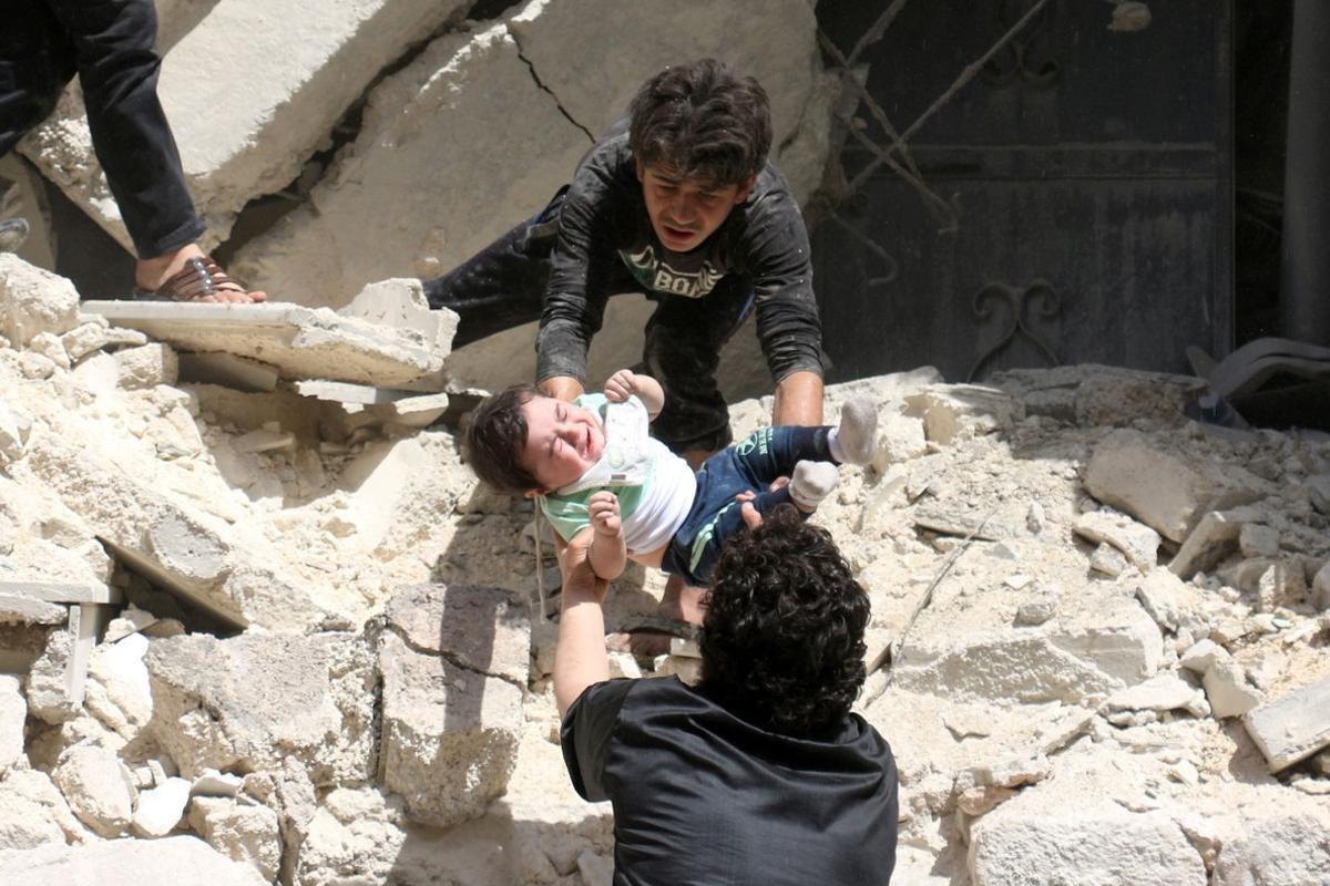Evacuación de un niño de un edificio destruido en Alepo.