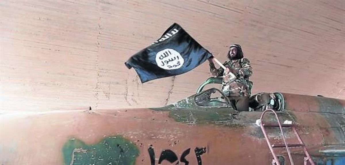 Un militante del Estado islámico ondea una bandera del califato en Raqqa (Siria). Un militante del Estado islámico ondea una bandera del califato en Raqqa (Siria).