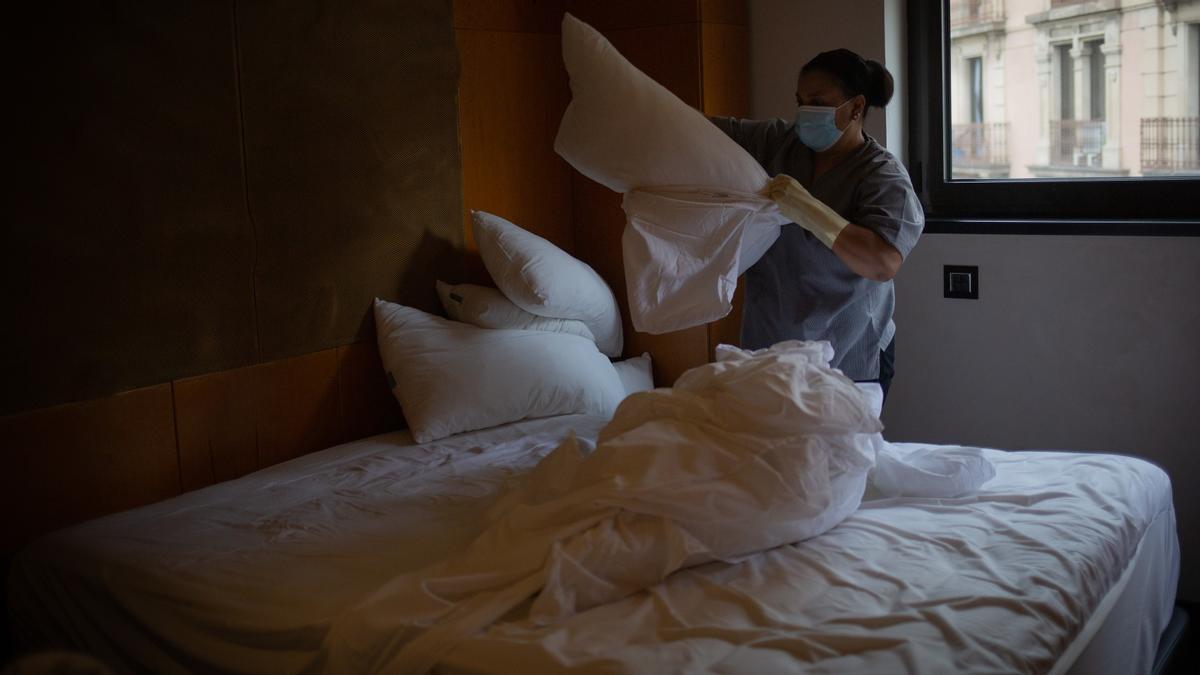 Una camarera de pisos cambia las sábanas de una cama de una habitación de un hotel de Barcelona, en noviembre de 2020.