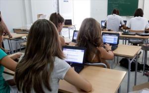 Alumnos de secundaria, manejándose en clase con ordenadores.