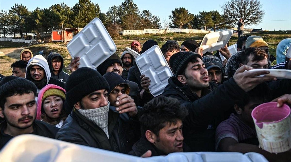 Un grupo de migrantes esperan que les sirvan comida en teritorio turco mientras esperan cruzar el río Meritsa para entrar en Grecia. Un grupo de migrantes esperan que les sirvan comida en teritorio turco mientras esperan cruzar el río Meritsa para entrar en Grecia.
