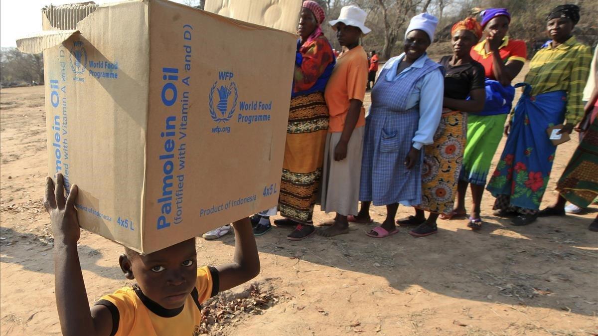 Un niño carga con una caja de alimentos de la PAM en Zimbabue, en una foto del 2015.