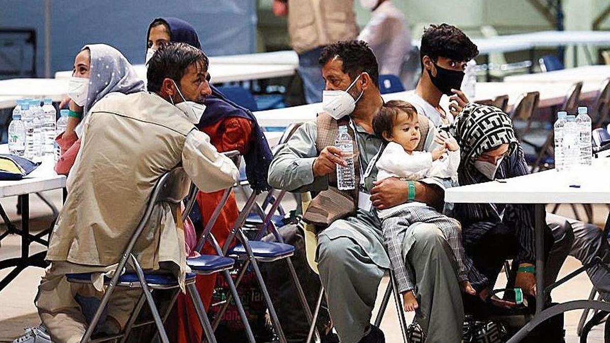 Ciudadanos españoles y afganos descansan tras su llegada a la base aérea de Torrejón.