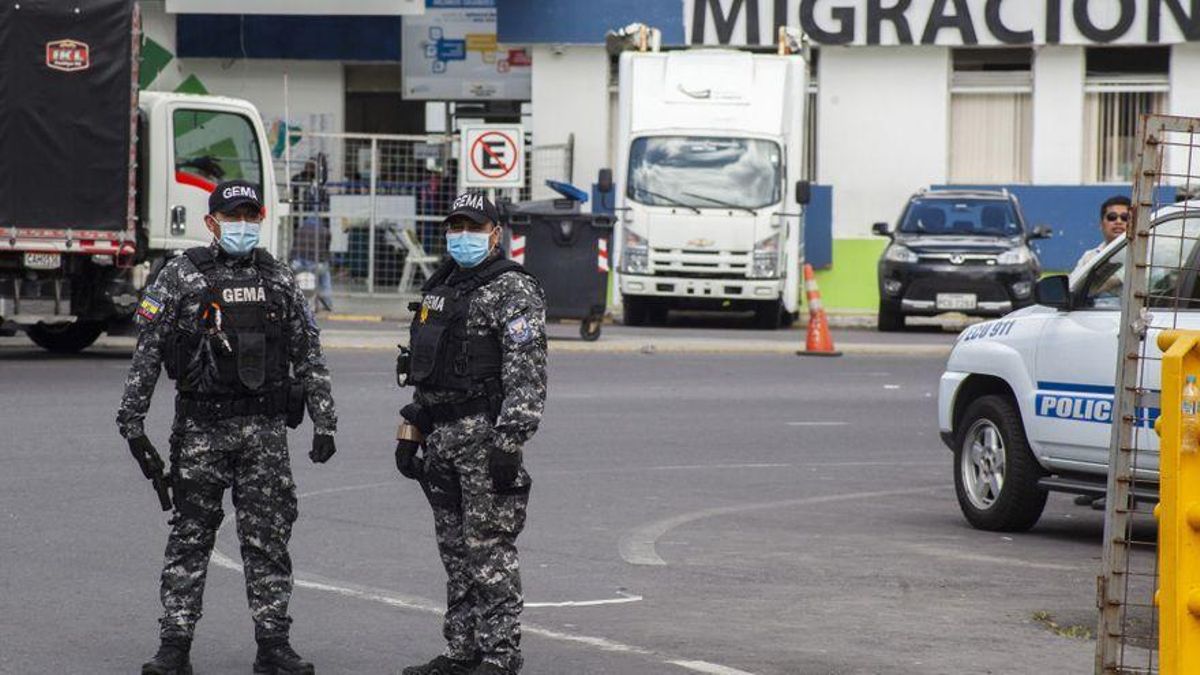 Dos agentes antinarcóticos de la policía nacional ecuatoriana con protectores bucales esperan a los vehículos en la frontera con Colombia para realizar controles de rutina, en medio del brote de coronavirus. Dos agentes antinarcóticos de la policía nacional ecuatoriana con protectores bucales esperan a los vehículos en la frontera con Colombia para realizar controles de rutina, en medio del brote de coronavirus.
