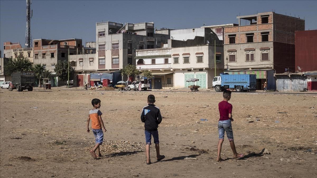 Unos niños juegan a fútbol en un descampado en un barrio de Alcazarquivir.