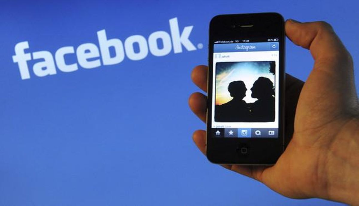 Un usuario de smartphone, delante de un logotipo de Facebook. Un usuario de smartphone, delante de un logotipo de Facebook.