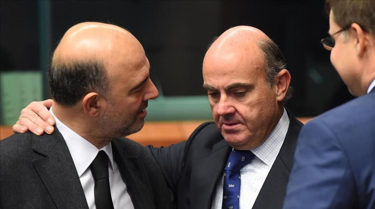 El ministro de Economía en funciones, Luis de Guindos, y el comisario de Asuntos Económicos, Pierre Moscovici, en presencia del vicepresidente de la Comisión Valdis Dombroskis, en un imagen de archivo. El ministro de Economía en funciones, Luis de Guindos, y el comisario de Asuntos Económicos, Pierre Moscovici, en presencia del vicepresidente de la Comisión Valdis Dombroskis, en un imagen de archivo.