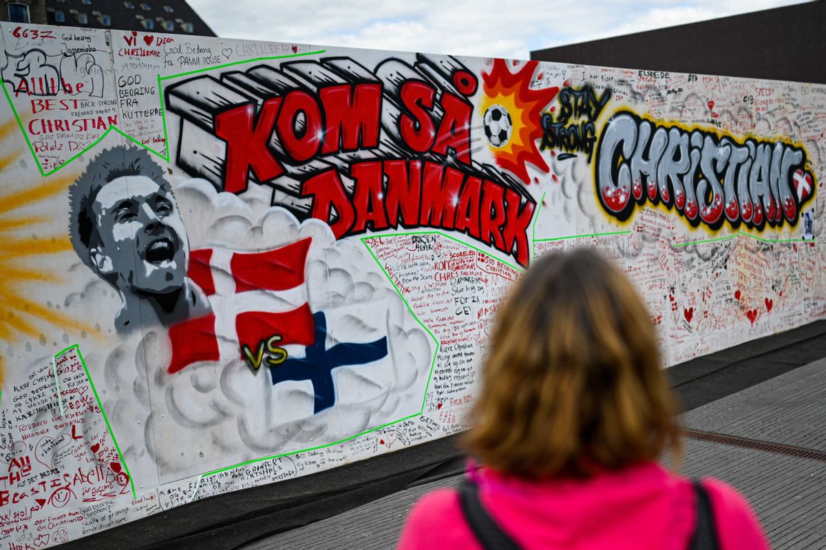 Una persona observa el mural pintado en Copenhague con mensajes escritos por la afición danesa. Una persona observa el mural pintado en Copenhague con mensajes escritos por la afición danesa.