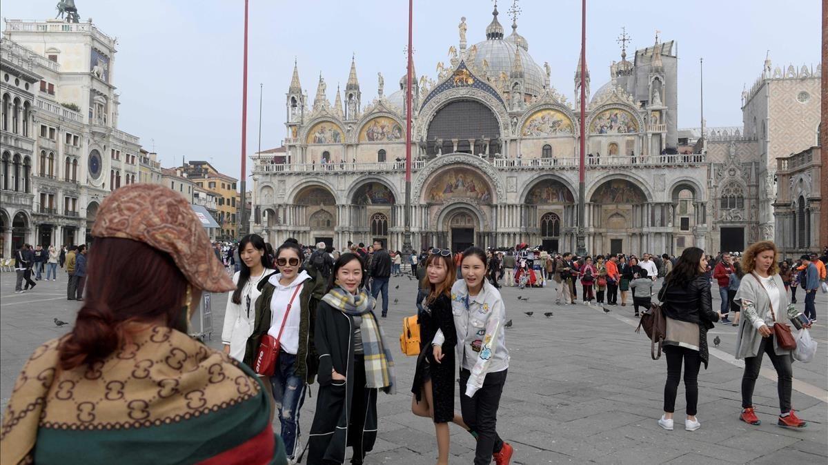 Turistas se hacen fotos frente a la catedral de San Marco, en Venecia, el 20 de octubre.