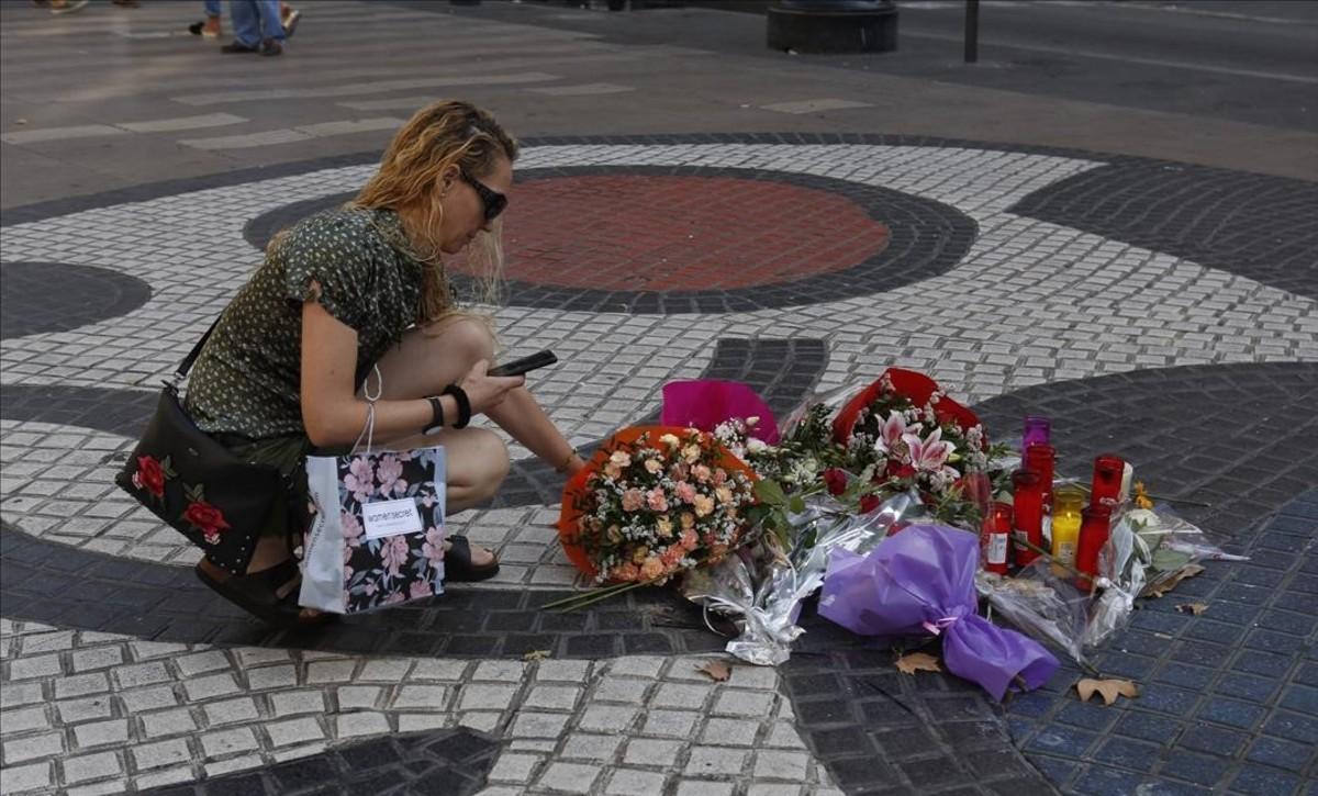 Una mujer deposita flores en La Rambla, en la víspera del primer aniversario del atentado del 17A.