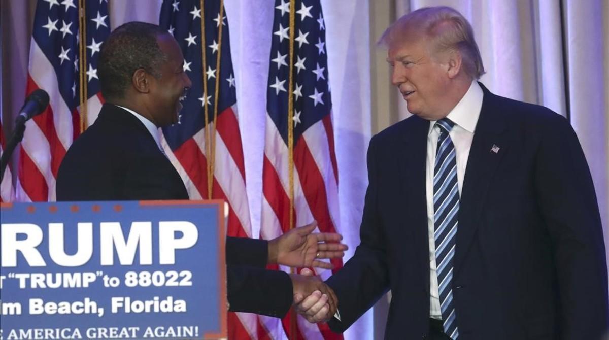 Trump (derecha) estrecha la mano del excandidato Ben Carson, en Palm Beach (Florida), este viernes.