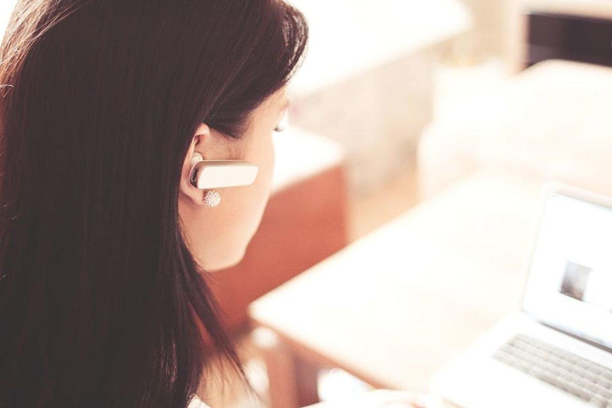 Una mujer habla por teléfono mientras trabaja. Una mujer habla por teléfono mientras trabaja.
