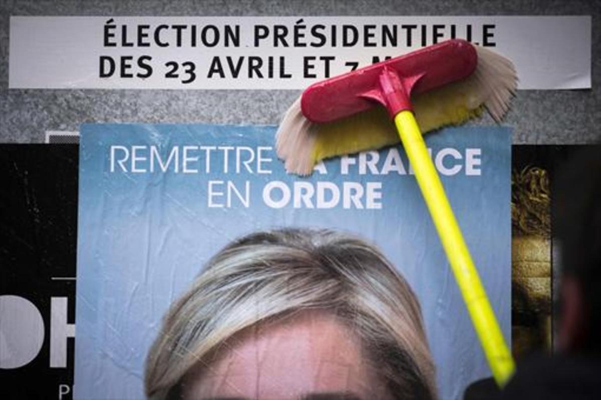 Un empleado del Frente Nacional pega un cartel electoral de Marine Le Pen al inicio de la campaña.