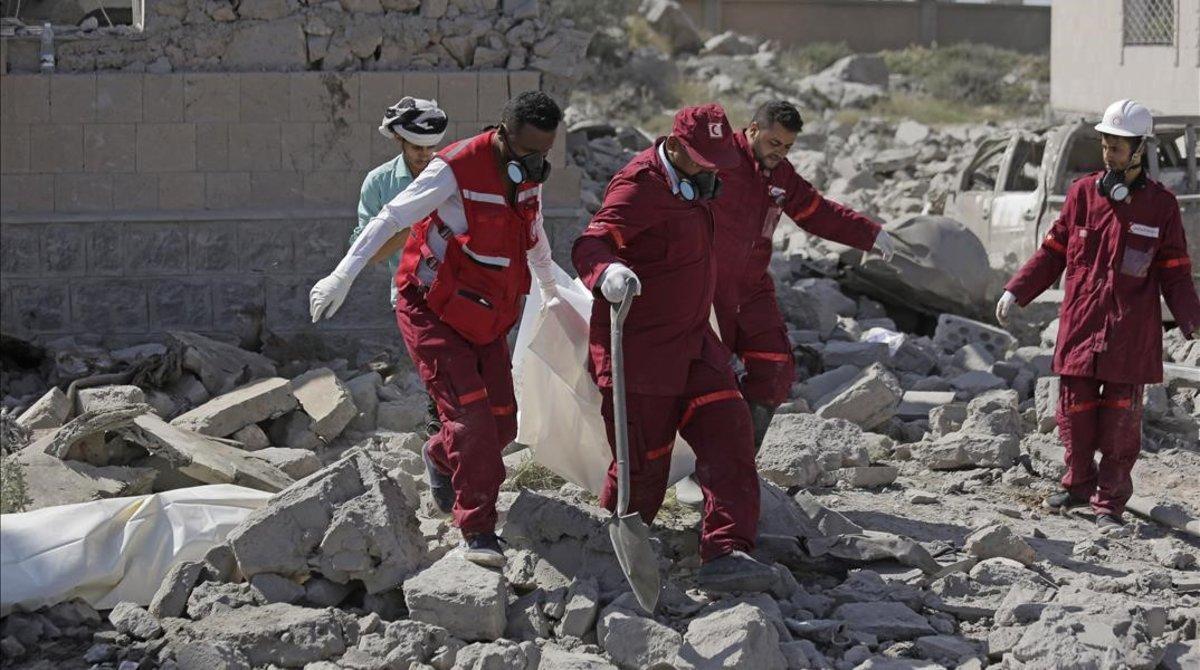 Los servicios de emergencia sacan un cadáver de los escombros del centro de detención bombardeado por Arabia Saudí en Yemen.