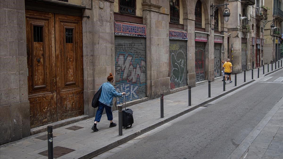 Varios establecimientos del barrio Gòtic de Barcelona, con la persiana bajada, un día laborable al mediodía de julio del 2020. Varios establecimientos del barrio Gòtic de Barcelona, con la persiana bajada, un día laborable al mediodía de julio del 2020.