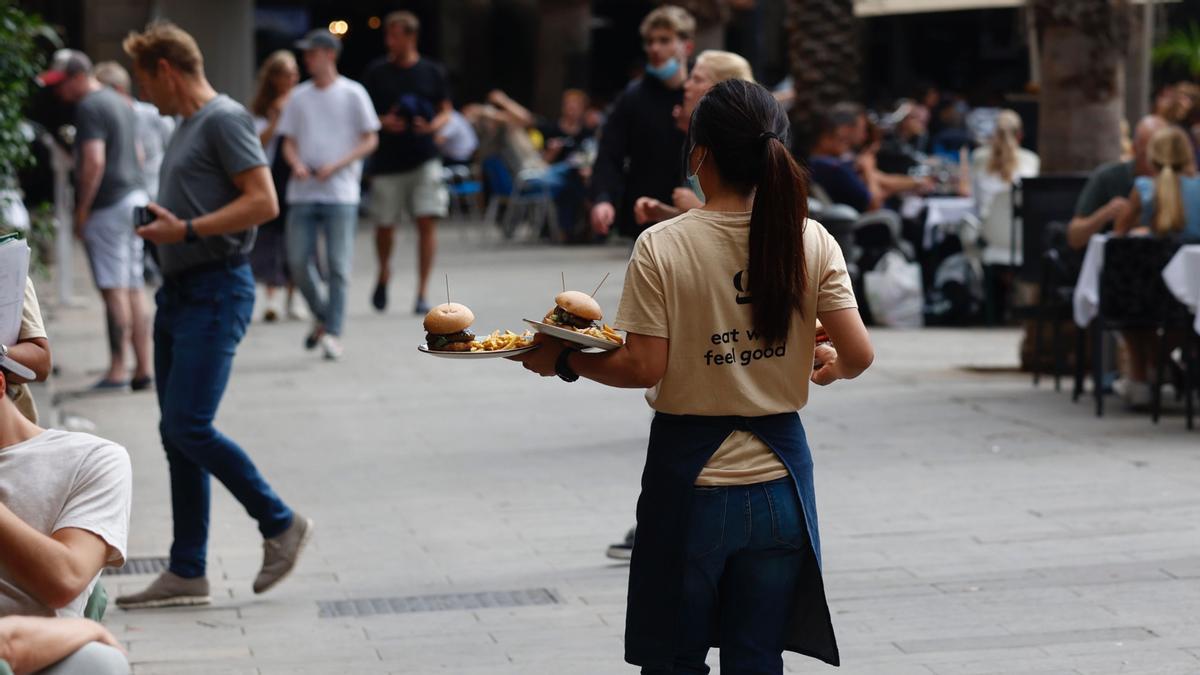 Una camarera trabajando en las terrazas de la Plaza Reial de Barcelona 