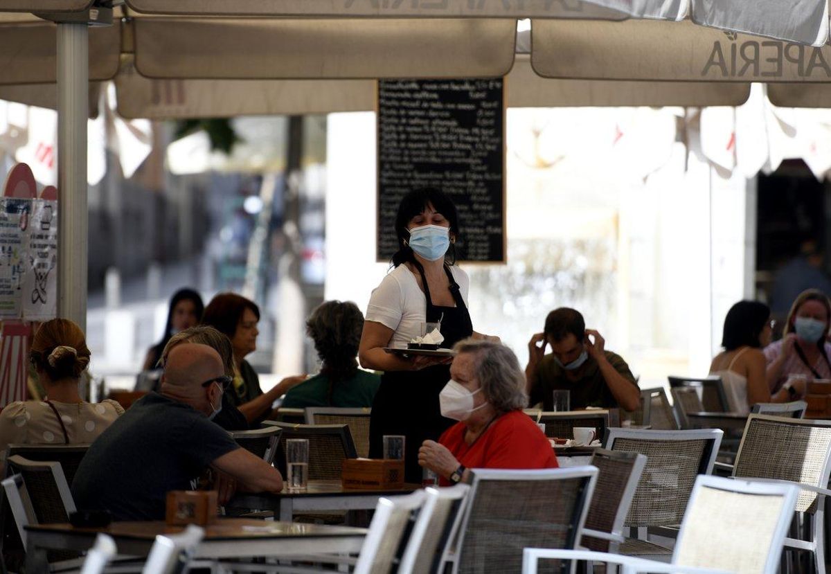 Una camarera atiende a unos clientes en una terraza de Madrid. Una camarera atiende a unos clientes en una terraza de Madrid.