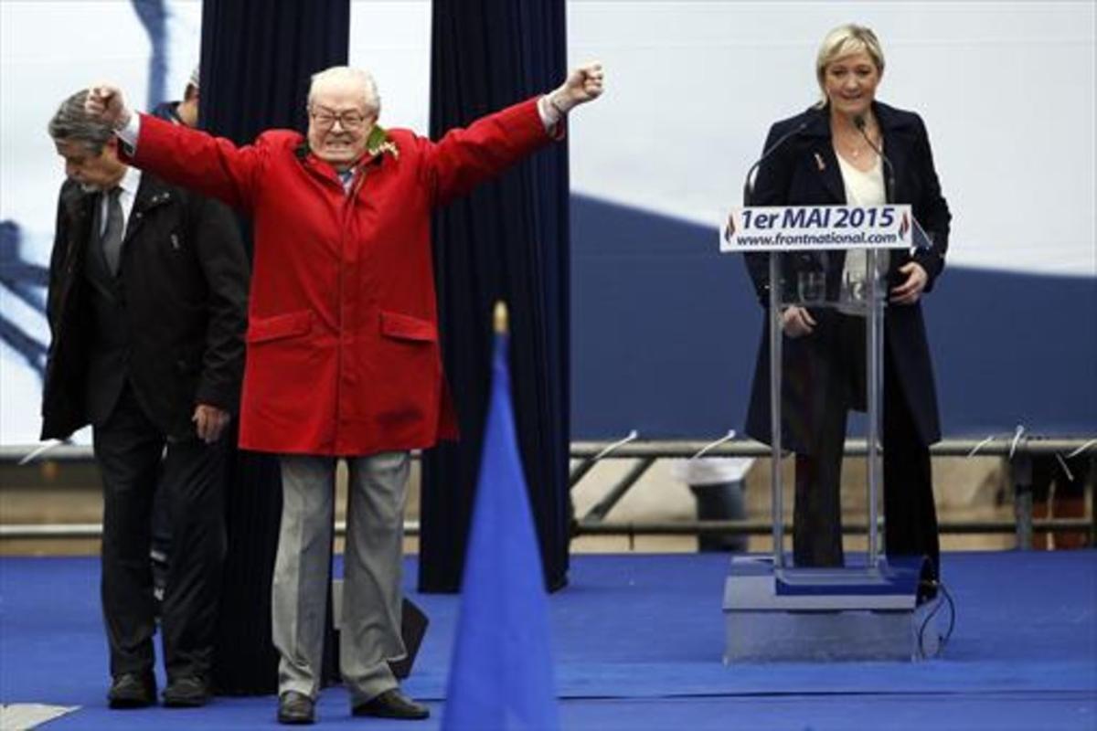 Jean-Marie Le Pen gesticula junto a su hija y presidenta del FN, Marine, en un acto del partido en París.