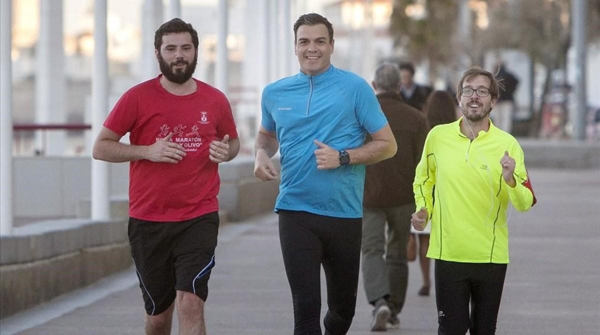 Pedro Sánchez corre junto a dos simpatizantes, este lunes en Cádiz.