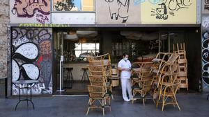 Sillas de una terraza de un bar de Barcelona amontonadas en la puerta, este miércoles.