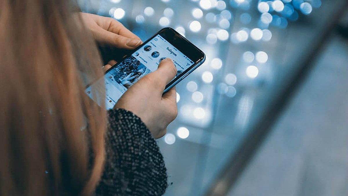 Una chica consulta la aplicación en su teléfono móvil de Instagram. Una chica consulta la aplicación en su teléfono móvil de Instagram.