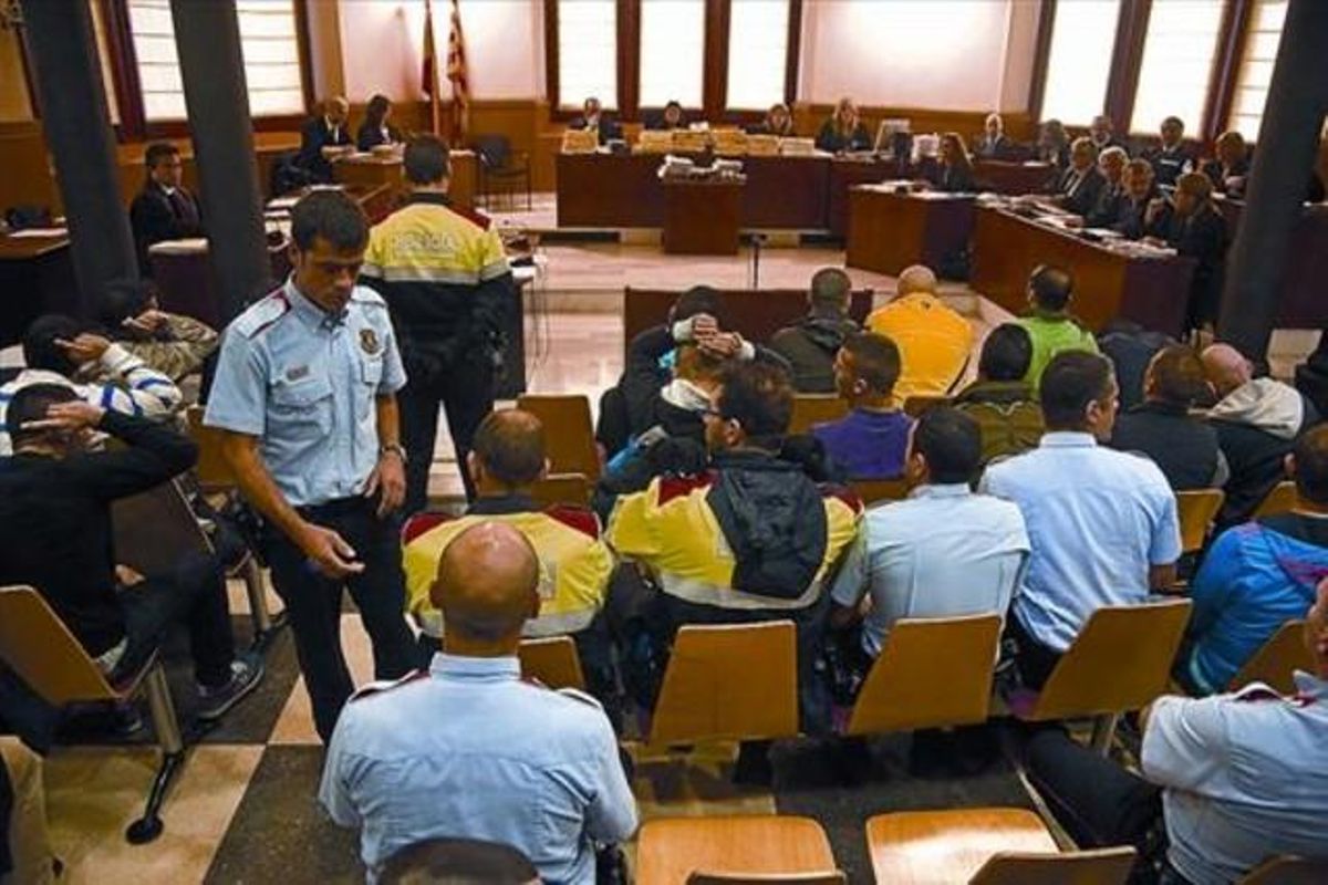 Agentes de los Mossos custodian a los procesados, al principio de la sesión de ayer. Agentes de los Mossos custodian a los procesados, al principio de la sesión de ayer.