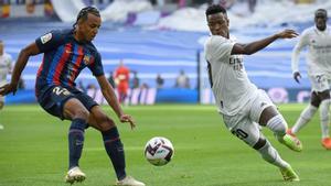 Jules Kounde, compite con el delantero brasileño del Real Madrid Vinicius Junior durante el partido de fútbol entre el Real Madrid CF y el FC Barcelona en el estadio Santiago Bernabeu.