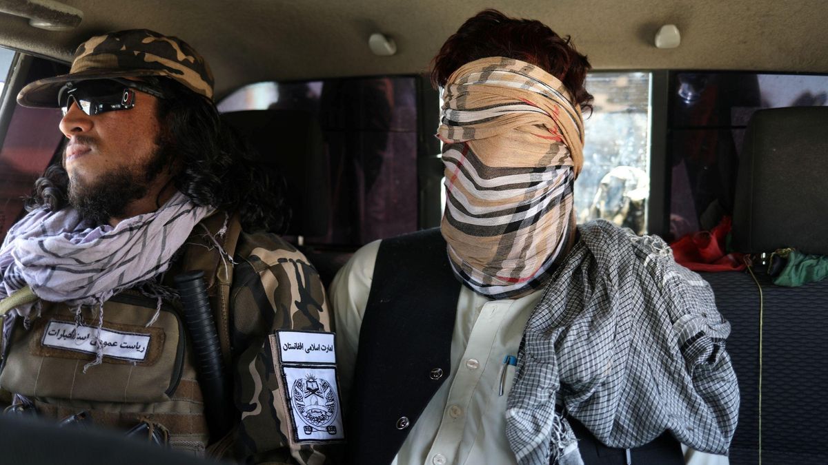 Un sospechoso de pertenecer al ISIS, con una venda en los ojos, junto a un miembro del ejército talibán en Kabul Un sospechoso de pertenecer al ISIS, con una venda en los ojos, junto a un miembro del ejército talibán en Kabul