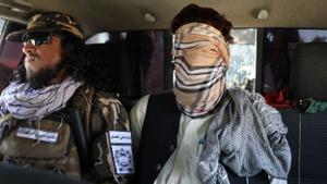 Un sospechoso de pertenecer al ISIS, con una venda en los ojos, junto a un miembro del ejército talibán en Kabul
