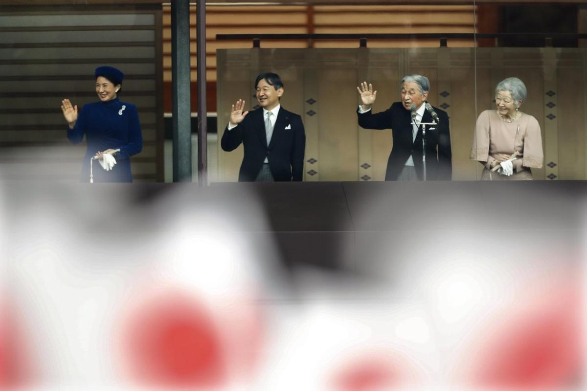 Emperor Akihito  waves to national flag-waving well-wishers with Empress Michiko,  Crown Prince Naruhito and Crown Princess Masako after delivering his speech marking his 85th birthday  his last birthday on the throne  at the Imperial Palace in Tokyo. EFE EPA KIMIMASA MAYAMA