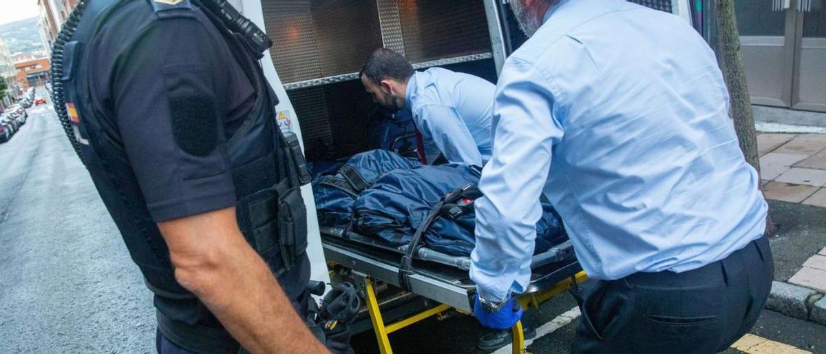 Los empleados de la funeraria, con el cuerpo de Ángeles Rodríguez ante la mirada de un policía. Los empleados de la funeraria, con el cuerpo de Ángeles Rodríguez ante la mirada de un policía.