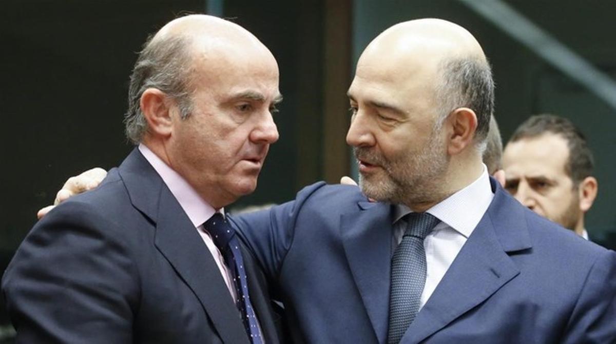 El ministro Luis de Guindos conversa con el comisario de Asuntos Economicos, Pierre Moscovici, en Bruselas el 14 de enero.