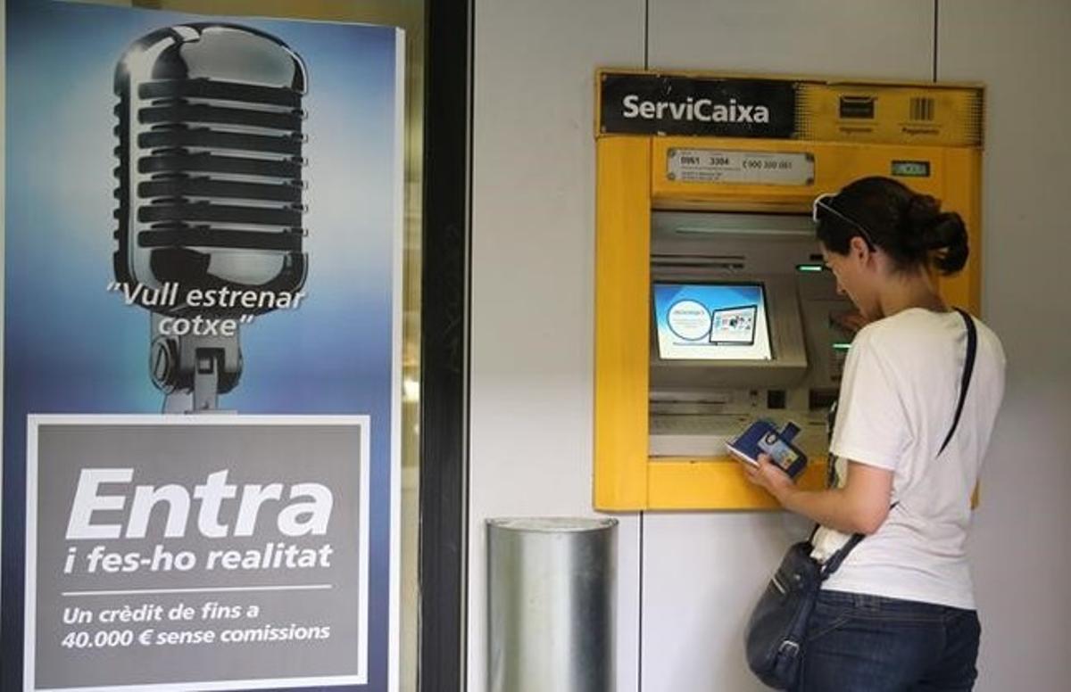 Una mujer operando en un cajero automático en Barcelona.