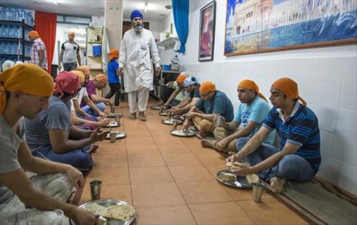 Comensales en el interior del Sikh Gurudwara Gurdarshan Sahib Ji, el templo sij de la calle Hospital, en Barcelona. Comensales en el interior del Sikh Gurudwara Gurdarshan Sahib Ji, el templo sij de la calle Hospital, en Barcelona.