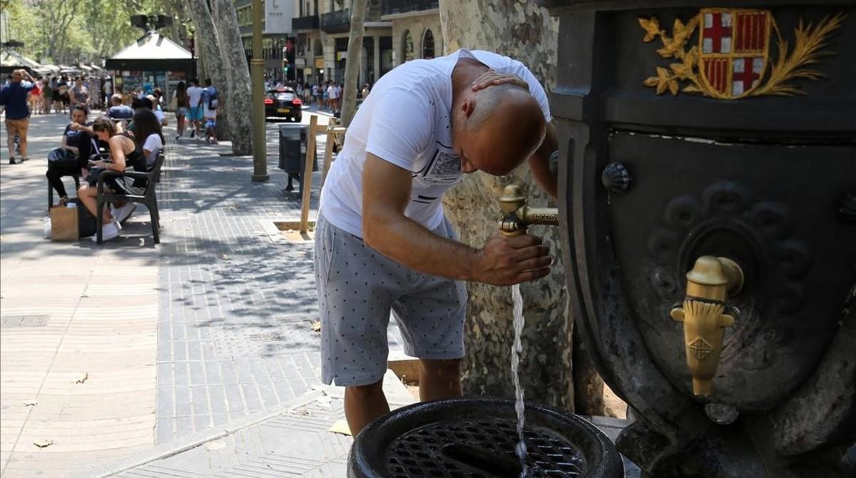 Un turista se refresca en la fuente de Canaletes, en la Rambla de Barcelona. Un turista se refresca en la fuente de Canaletes, en la Rambla de Barcelona.
