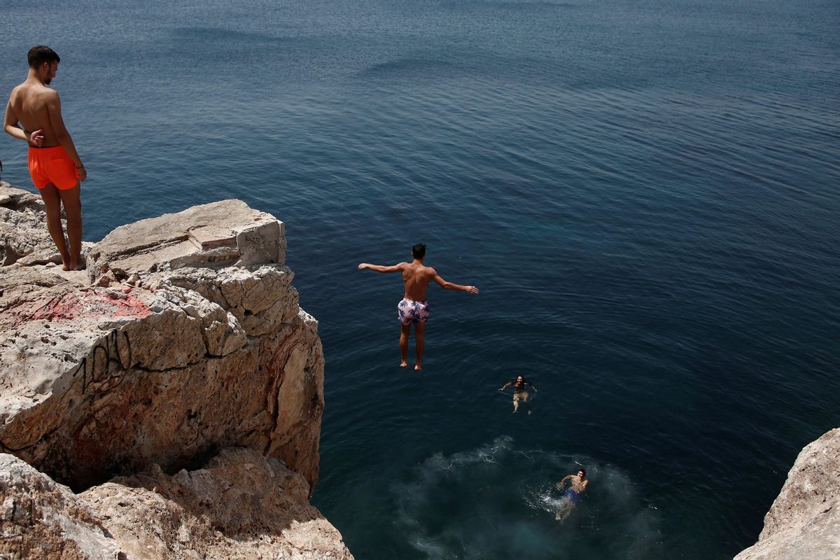 Un hombre se sumerge en el mar durante la ola de calor en Varkiza, cerca de Atenas. Un hombre se sumerge en el mar durante la ola de calor en Varkiza, cerca de Atenas.