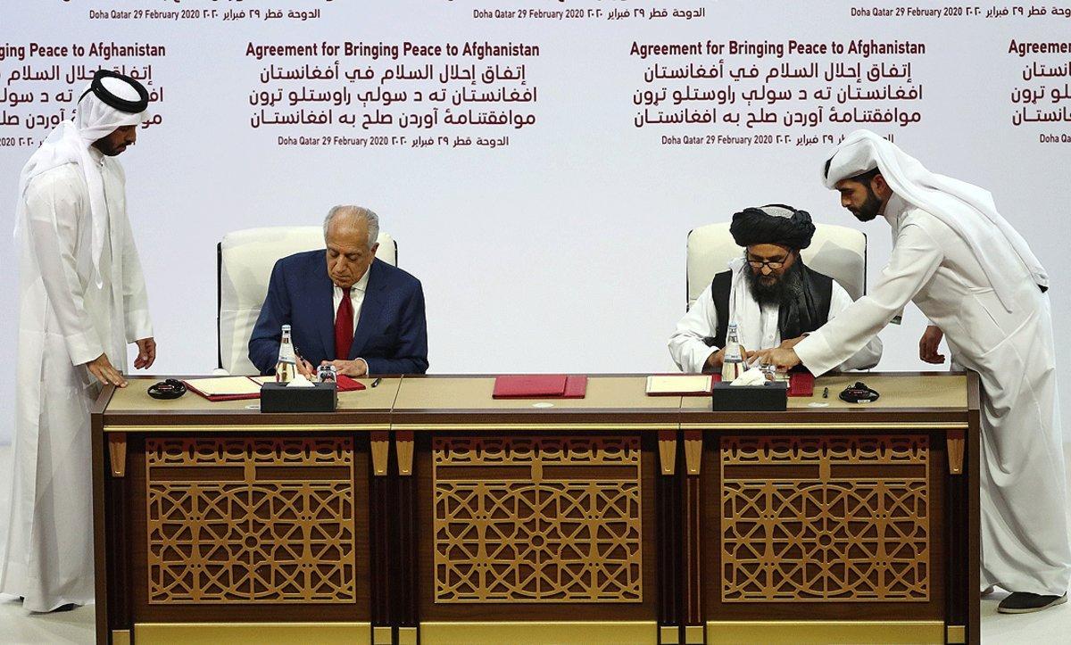 El enviado especial de EEUU, Zalmay Khalilzad, y el líder político talibán, Mullah Abdul Ghani Baradar, firman el acuerdo de paz, este sábado en Doha.