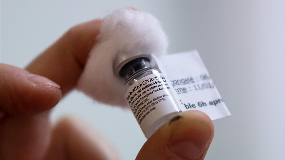 Una enfermera muestra un vial de la vacuna de Pfizer y BioNTech.