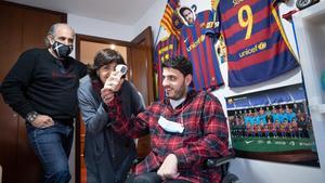 Pol Otero Arús, en su habitación plagada de fotografías del Barça, junto a sus padres Montse y Carlos.