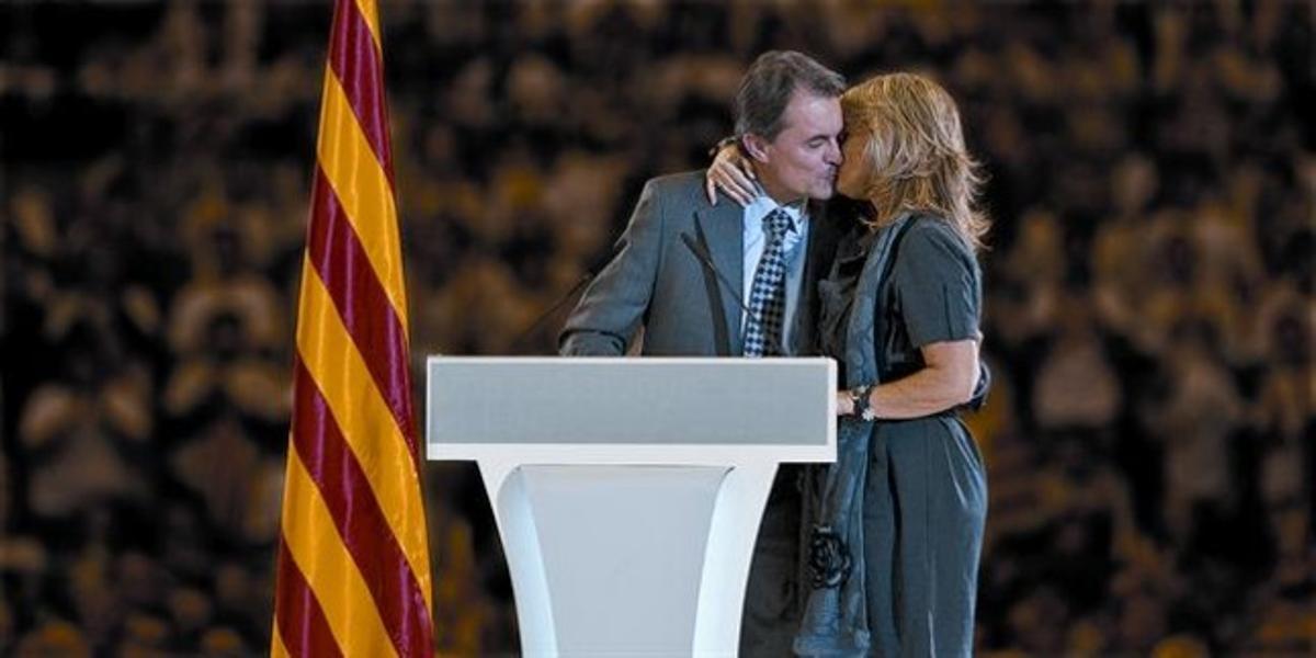 Artur Mas besa a su mujer, Helena Rakosnik, a la que dedicó parte de su mitin, ayer en el Palau Sant Jordi.