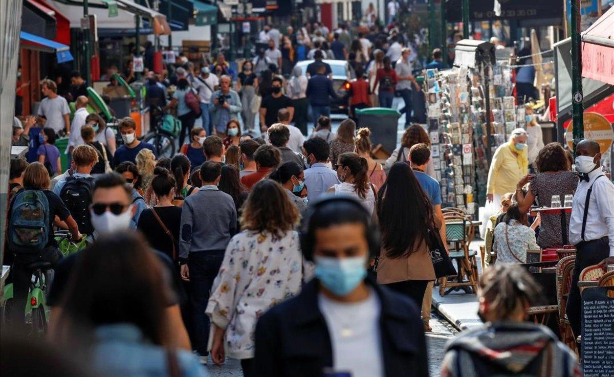 Paseantes con mascarilla en una calle del centro de París. Paseantes con mascarilla en una calle del centro de París.