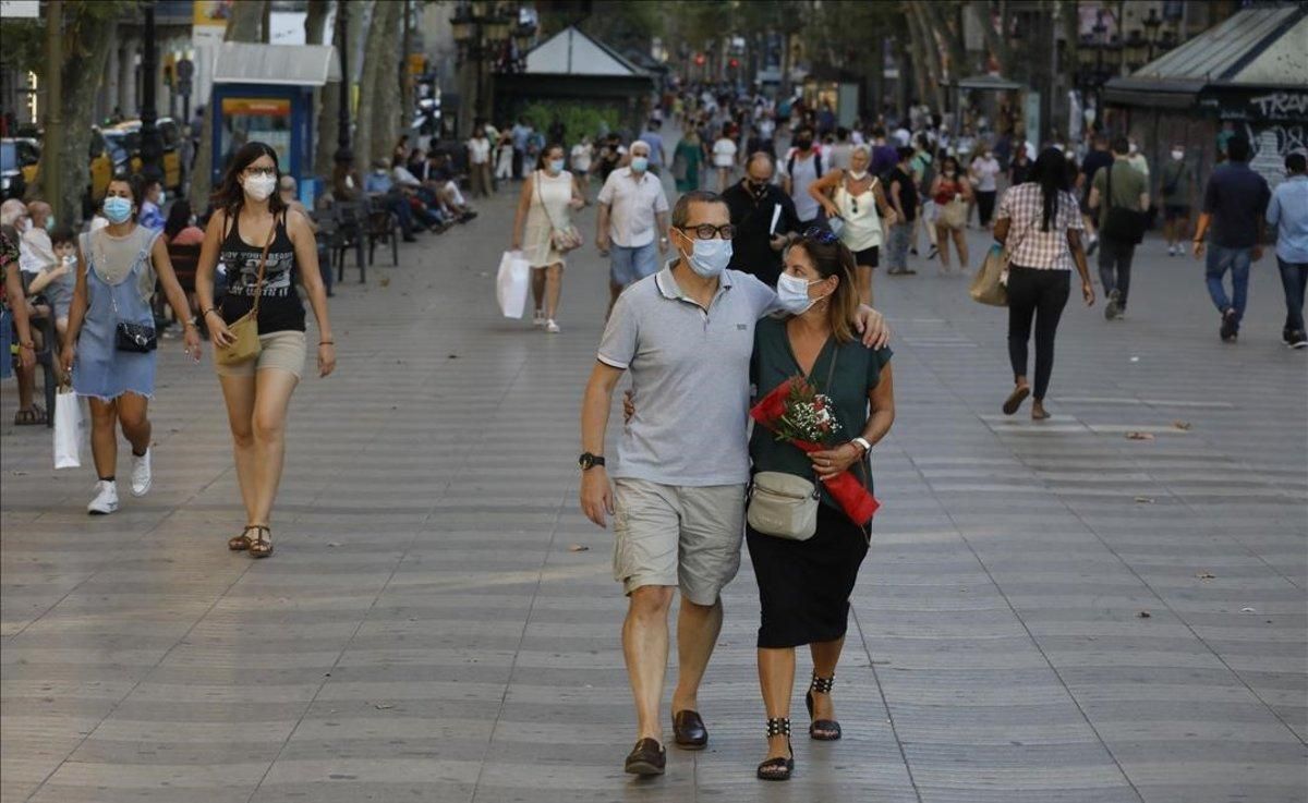 Gente con mascarilla pasea por la Rambla de Barcelona. Gente con mascarilla pasea por la Rambla de Barcelona.