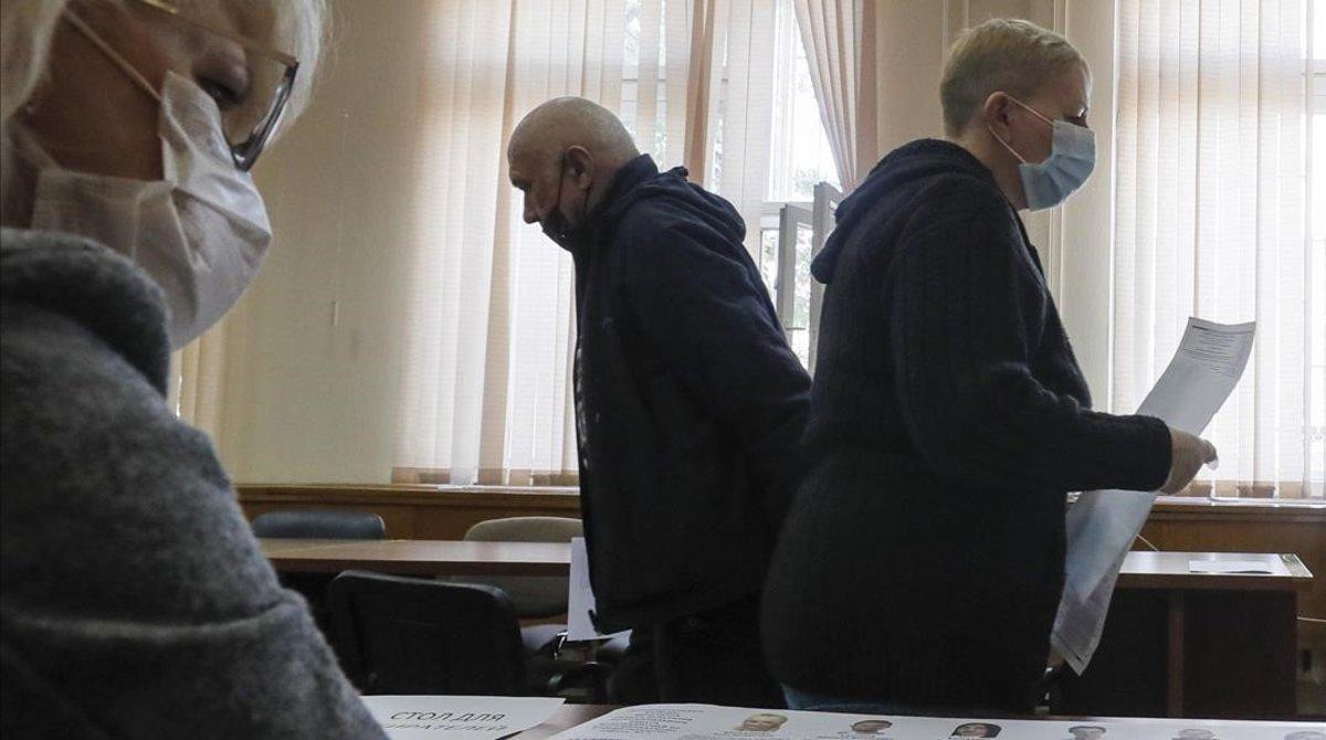 Electores rusos examinan las listas de candidatos en un colegio electoral.