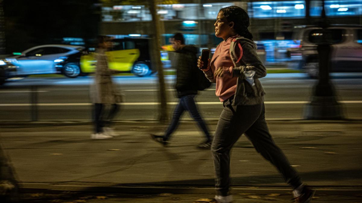 Una mujer corre de noche por la Diagonal, en 2021