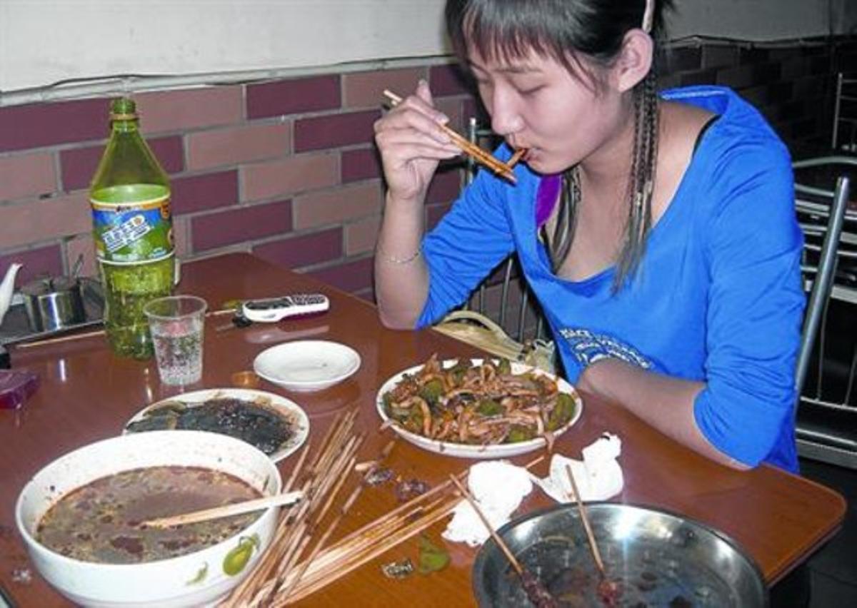Una joven come en un restaurante de comida de Xinjinag, en Pekín.