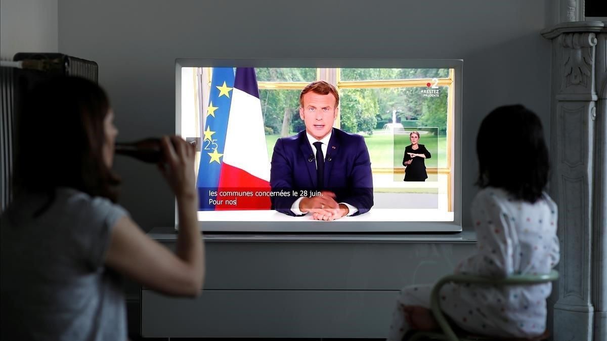 Una familia sigue este domingo el mensaje a la nación del presidente francés, Emmanuel Macron. Una familia sigue este domingo el mensaje a la nación del presidente francés, Emmanuel Macron.