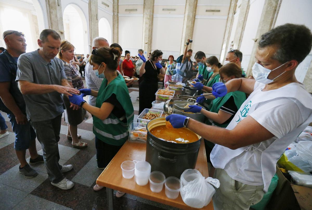 Evacuados de Mikolayiv reciben ayuda humanitaria y alimentos en la estación de Odesa, este jueves.