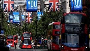 Autobuses pasan bajo banderas de la ’Union Jack’ y pancartas con mensajes a los héroes del coronavirus en Oxford Street.