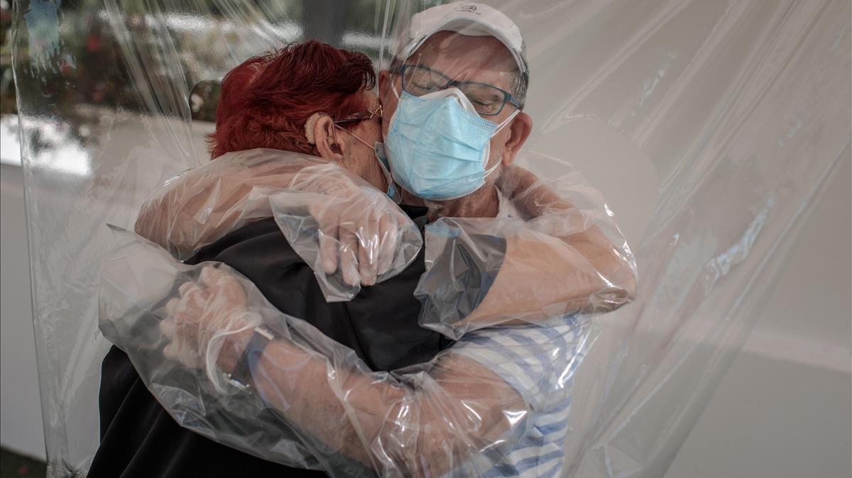 Una mujer interna en una residencia de mayores de València abraza a su sobrino a través de un plástico habilitado a tal efecto, el 17 de junio pasado.